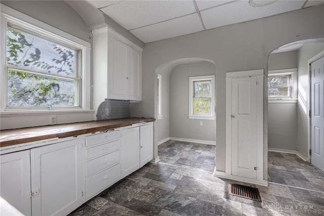 kitchen featuring wood counters, white cabinetry, and a wealth of natural light