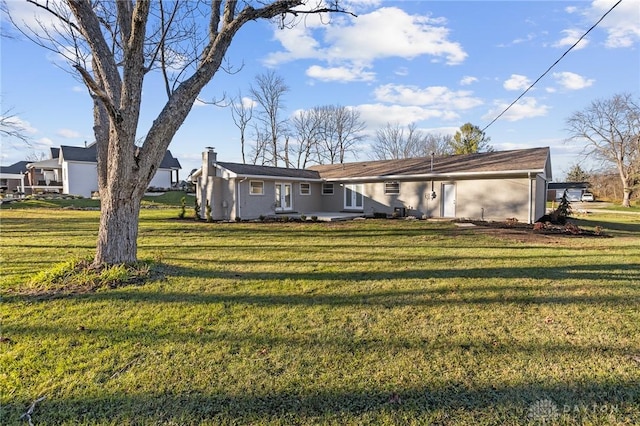 back of property with a lawn