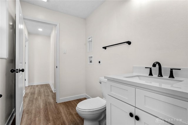 bathroom featuring vanity, toilet, and wood-type flooring