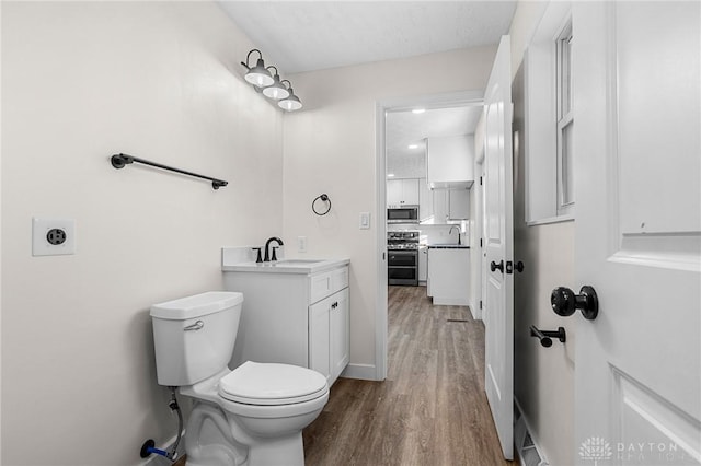 bathroom featuring vanity, hardwood / wood-style flooring, and toilet