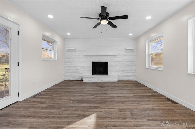 unfurnished living room with ceiling fan, a fireplace, and dark hardwood / wood-style floors