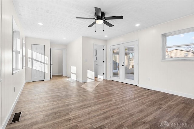 unfurnished living room featuring ceiling fan, french doors, light hardwood / wood-style floors, and a textured ceiling