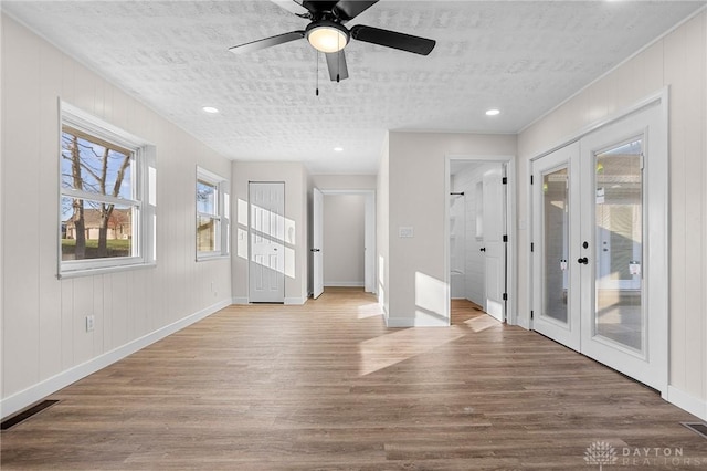 empty room featuring french doors, a textured ceiling, and hardwood / wood-style floors