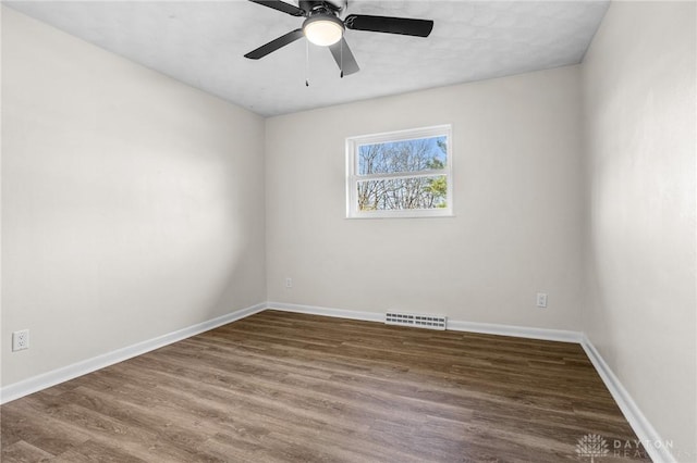 empty room with ceiling fan and dark hardwood / wood-style floors