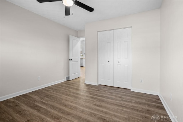 unfurnished bedroom featuring dark hardwood / wood-style flooring, a closet, and ceiling fan