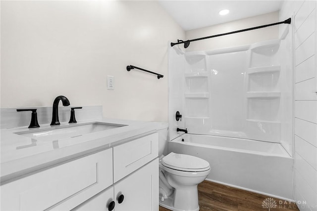 full bathroom featuring vanity, hardwood / wood-style flooring, toilet, and tiled shower / bath combo