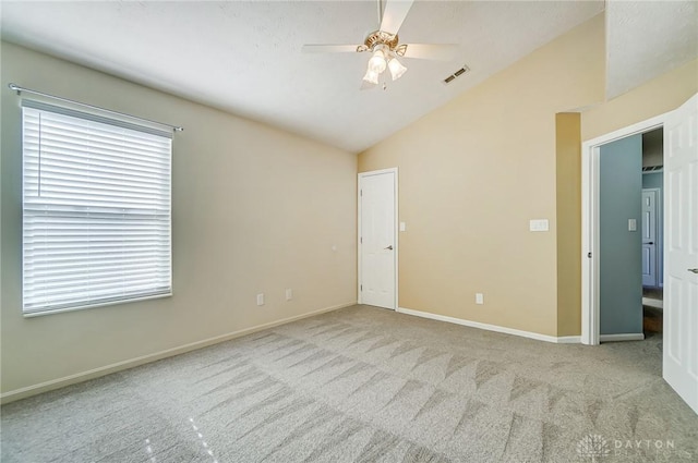 carpeted empty room with ceiling fan and lofted ceiling