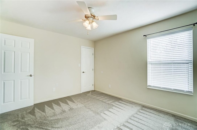 empty room featuring carpet flooring and ceiling fan