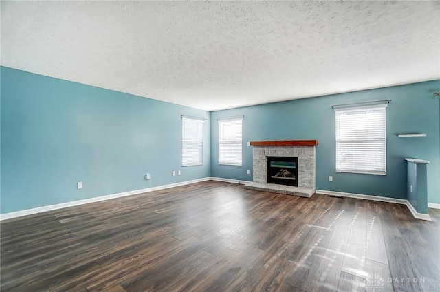 unfurnished living room featuring dark hardwood / wood-style flooring and a textured ceiling