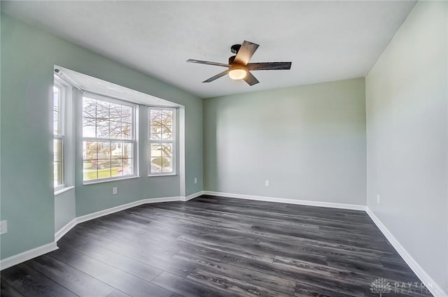 empty room with ceiling fan and dark hardwood / wood-style flooring