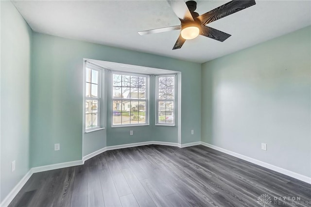 unfurnished room with ceiling fan and dark wood-type flooring