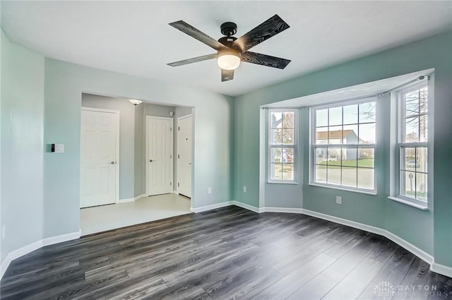 empty room featuring ceiling fan and dark wood-type flooring