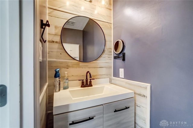 bathroom with wood walls and vanity