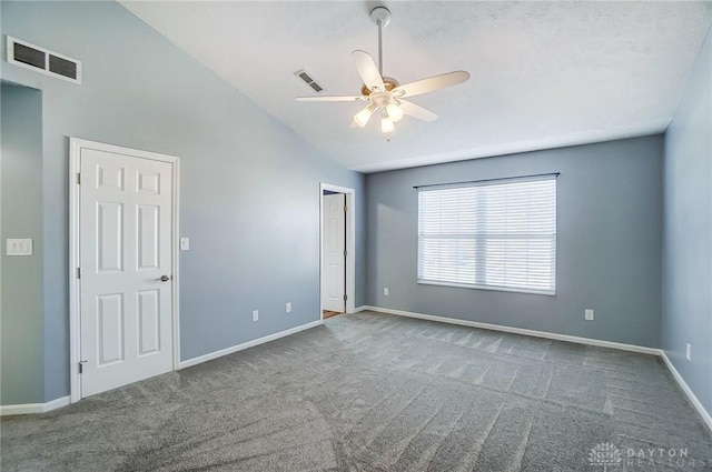 carpeted empty room with ceiling fan and lofted ceiling