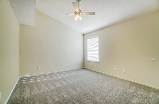 carpeted spare room featuring ceiling fan, lofted ceiling, and a textured ceiling