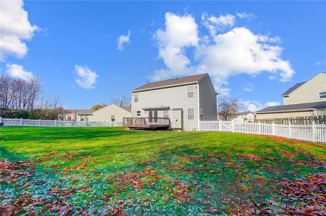 back of property with a yard and a wooden deck