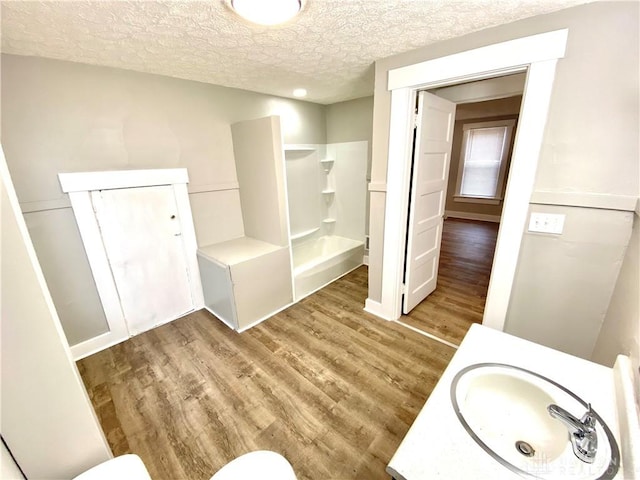 bathroom featuring hardwood / wood-style flooring, vanity, a textured ceiling, and walk in shower