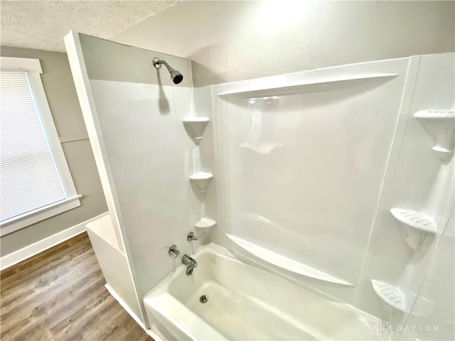 bathroom featuring bathing tub / shower combination, a textured ceiling, and hardwood / wood-style flooring