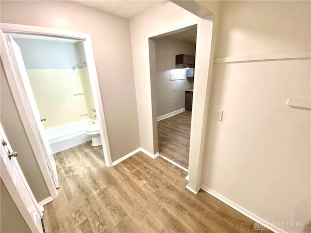 hallway featuring a textured ceiling and hardwood / wood-style flooring