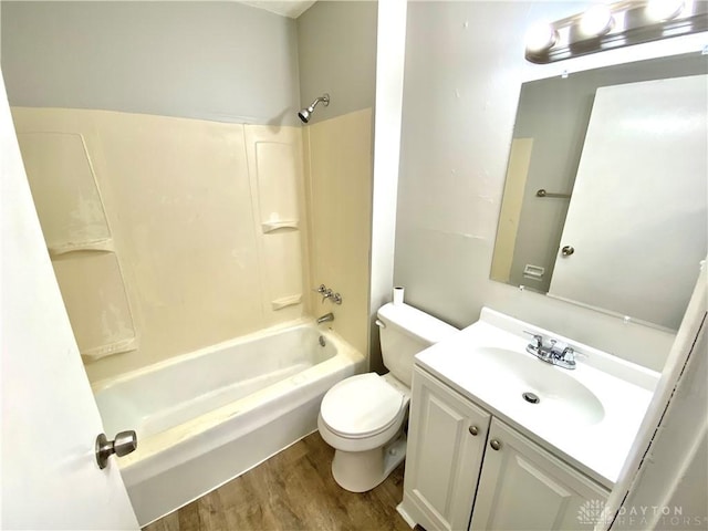 full bathroom featuring washtub / shower combination, wood-type flooring, vanity, and toilet