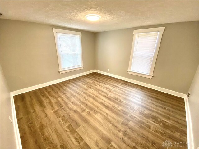 spare room with wood-type flooring and a textured ceiling