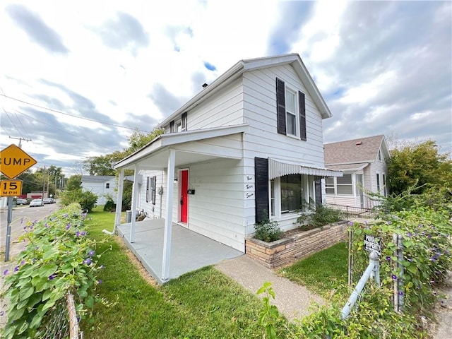 view of front of property featuring covered porch and a front lawn