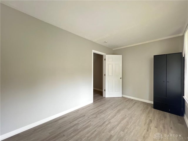 unfurnished bedroom featuring light hardwood / wood-style flooring and ornamental molding