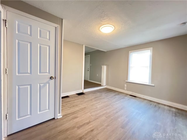 empty room featuring light hardwood / wood-style floors and a textured ceiling