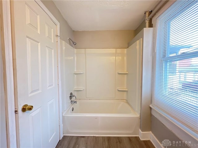 bathroom featuring hardwood / wood-style floors, a healthy amount of sunlight, and shower / bath combination