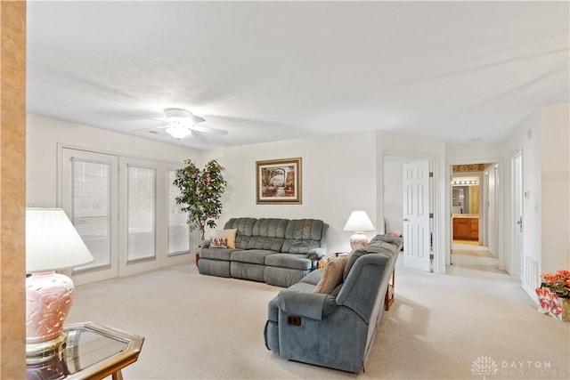 living room with ceiling fan and light colored carpet