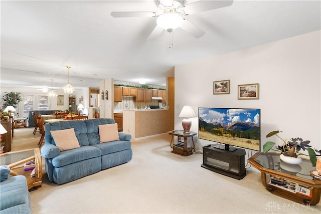 carpeted living room with ceiling fan with notable chandelier