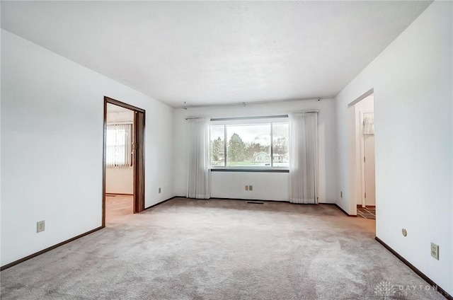 unfurnished room featuring light carpet