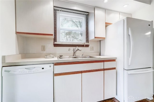 kitchen featuring decorative backsplash, white cabinetry, sink, and white appliances