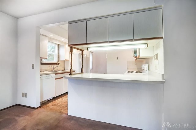 kitchen with carpet flooring, kitchen peninsula, gray cabinetry, and white appliances