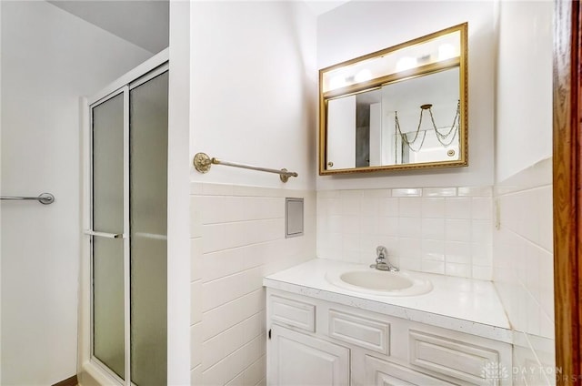 bathroom with vanity, walk in shower, and tile walls