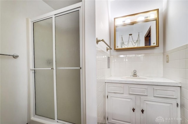 bathroom featuring vanity, walk in shower, and tile walls