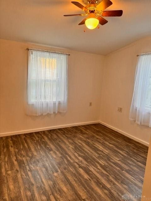 empty room with ceiling fan and dark wood-type flooring