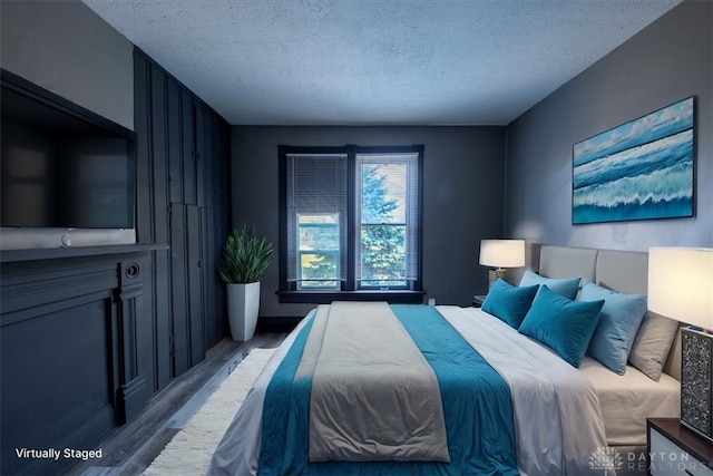 bedroom featuring wood-type flooring and a textured ceiling