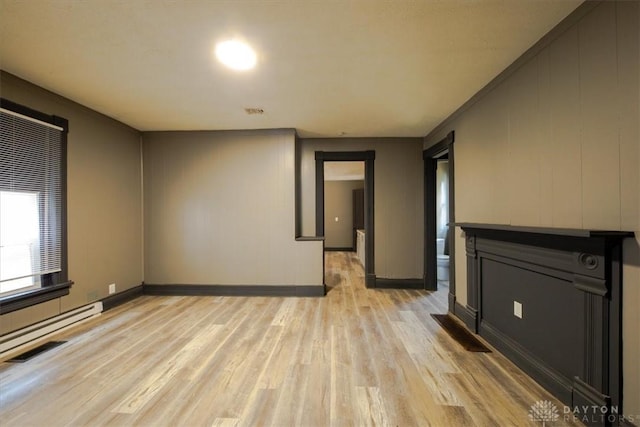 unfurnished living room with light wood-type flooring and a baseboard radiator