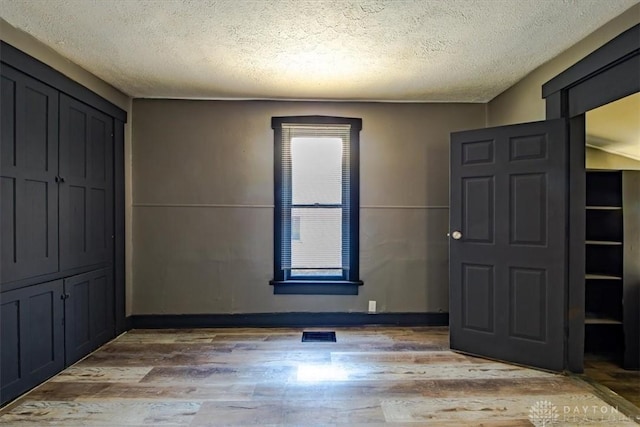 foyer featuring hardwood / wood-style flooring and a textured ceiling