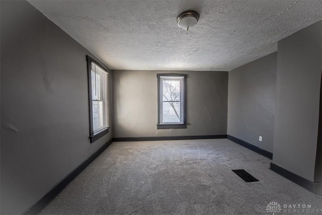 empty room featuring carpet floors and a textured ceiling