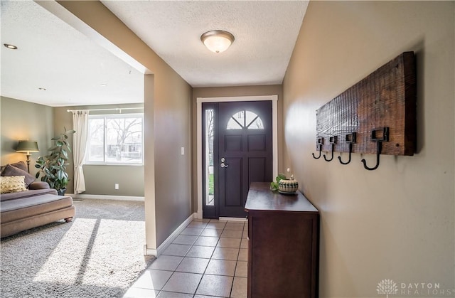 foyer with light tile patterned flooring and a textured ceiling