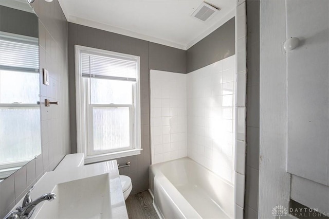 bathroom with hardwood / wood-style flooring, toilet, crown molding, and a wealth of natural light