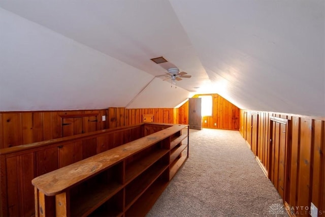 bonus room featuring wood walls, carpet, vaulted ceiling, and ceiling fan