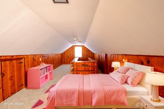 bedroom featuring carpet floors, wooden walls, and vaulted ceiling