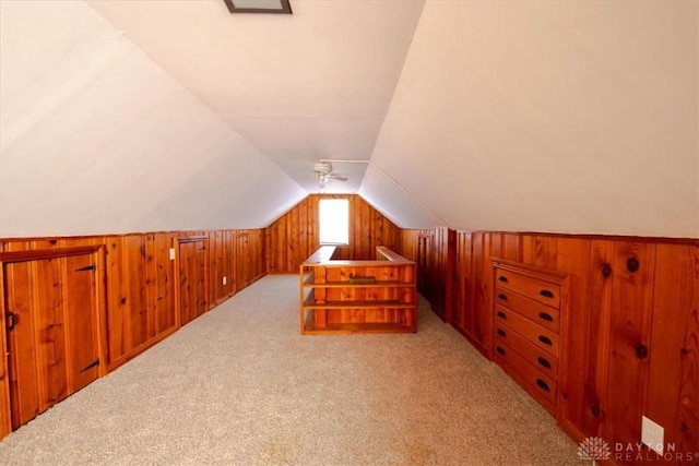 bonus room with light carpet, wood walls, and lofted ceiling