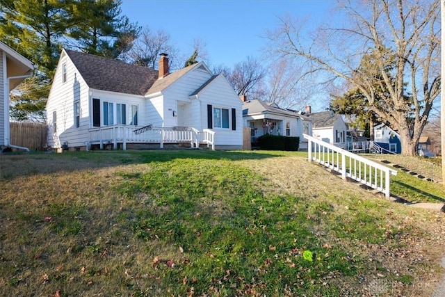 back of property with a yard and a wooden deck