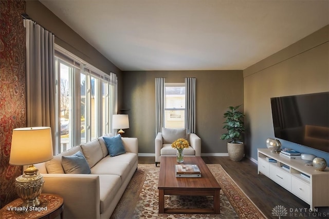 living room with plenty of natural light and dark wood-type flooring