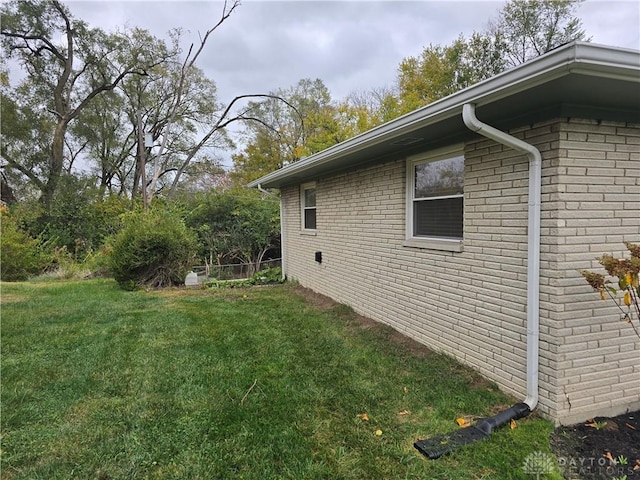 view of side of home with a yard