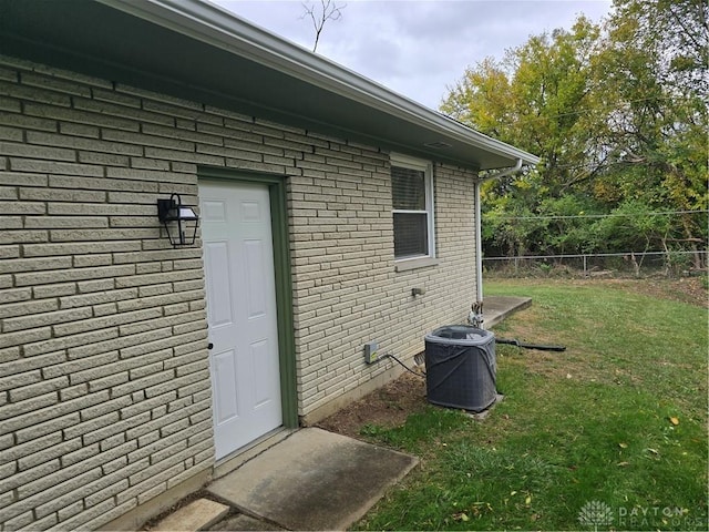 entrance to property featuring a yard and central AC